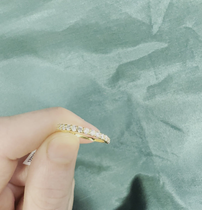 Hand holding yellow gold diamond anniversary band