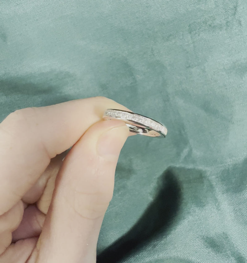 Hand holding diamond anniversary band with channel setting