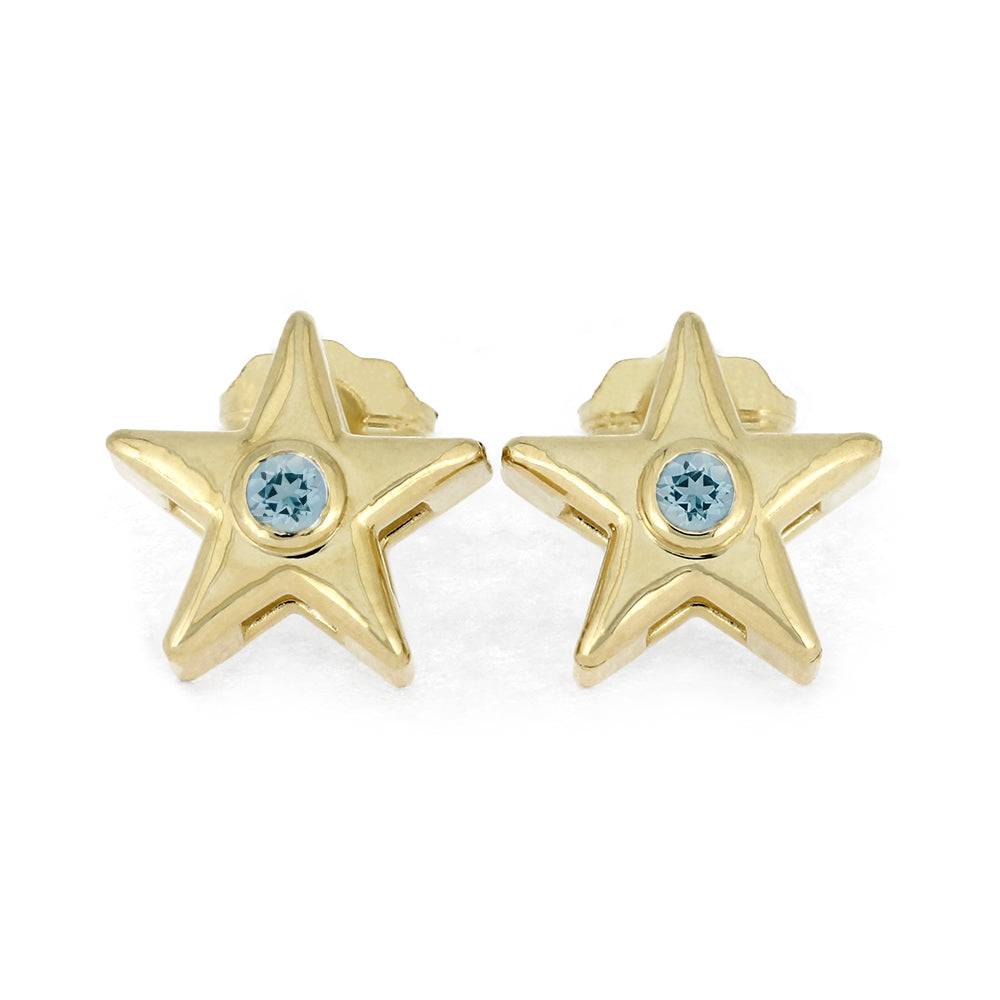 Gold star stud earrings with light blue birthstone on white background