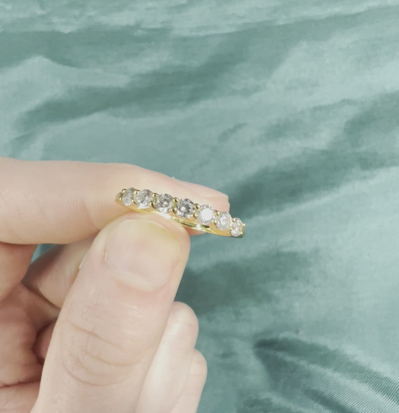 Hand holding yellow gold diamond wedding band