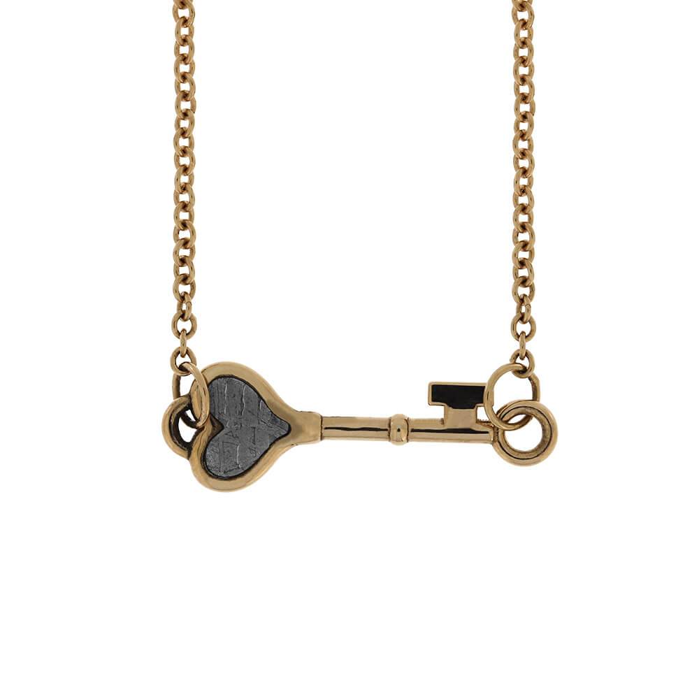Gold tiny key bracelet featuring meteorite heart inlay