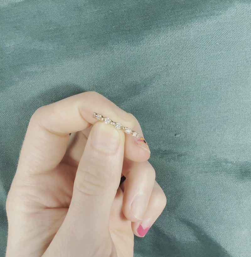 Hand holding rose gold diamond half eternity band