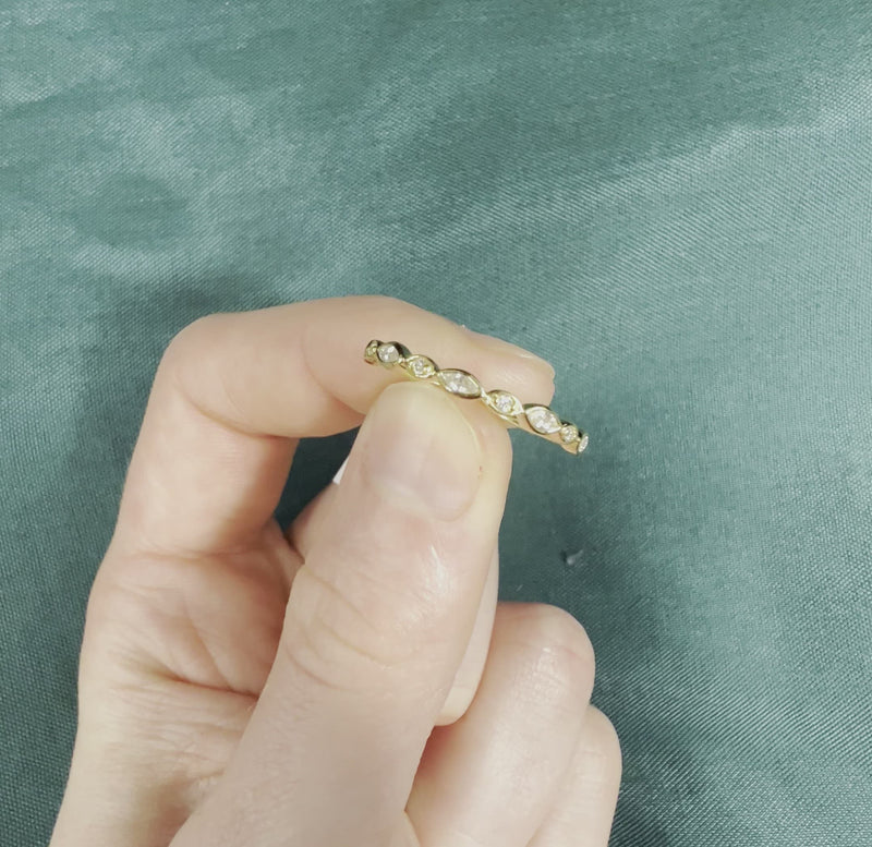 Hand holding yellow gold diamond stackable band