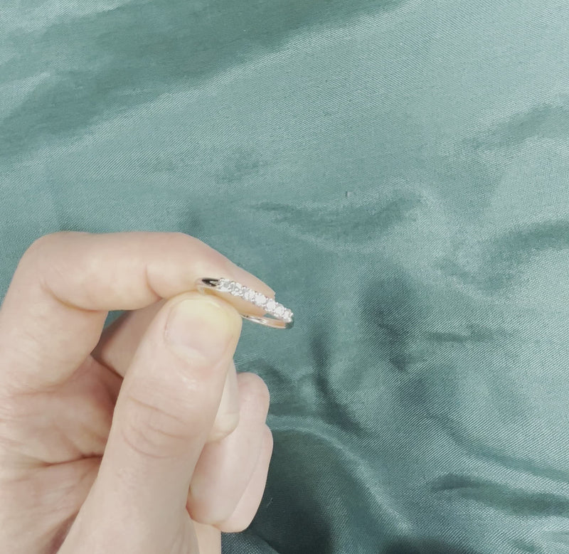 Hand holding 7-stone diamond ring with V-shaped prong