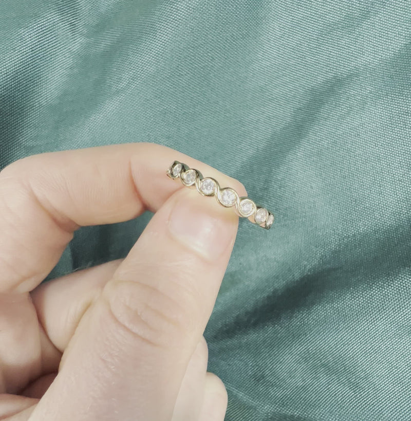 Hand holding rose gold diamond anniversary band