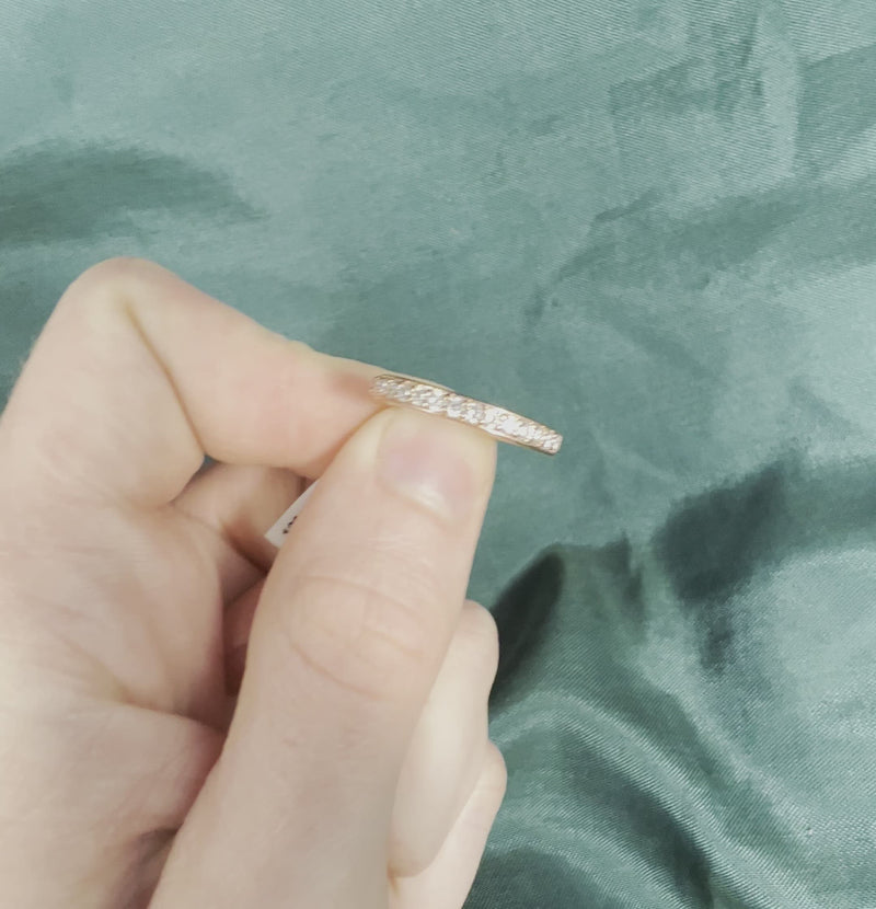 Hand holding rose gold diamond anniversary band