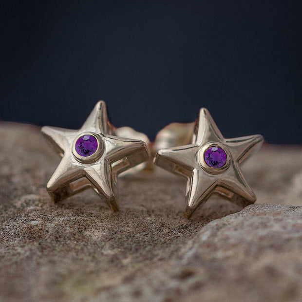 Gold star stud earrings with purple birthstone