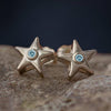 Gold star stud earrings with light blue birthstone