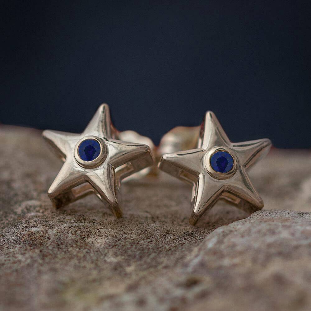 Gold star stud earrings with blue birthstone