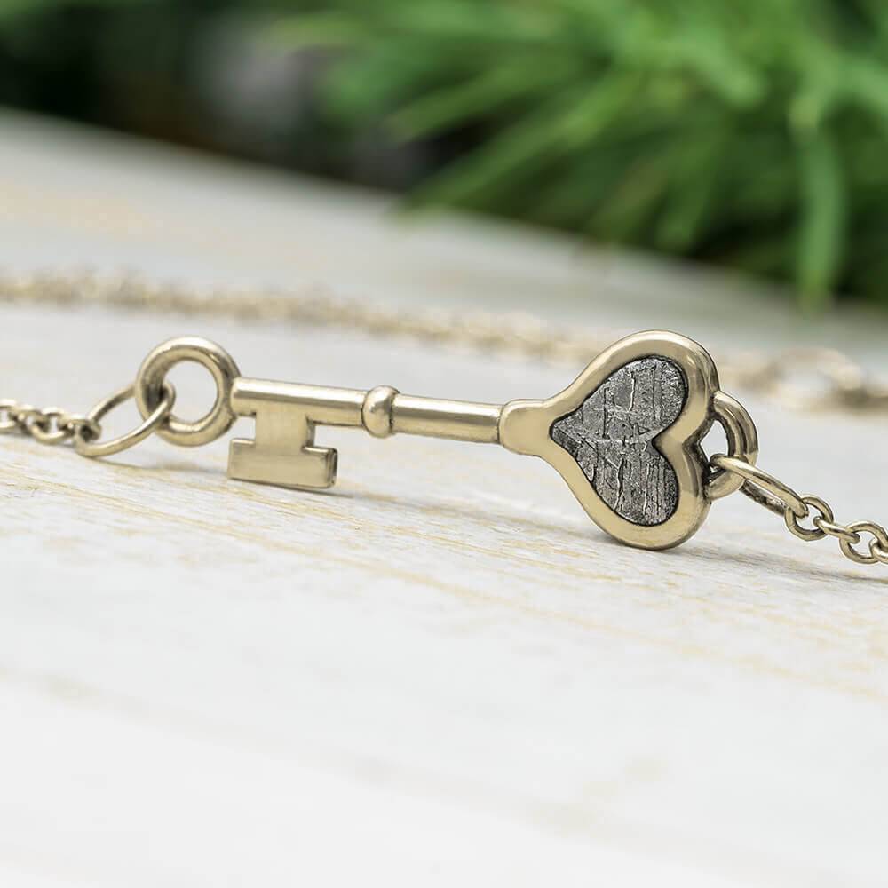 White gold tiny key bracelet with meteorite heart inlay