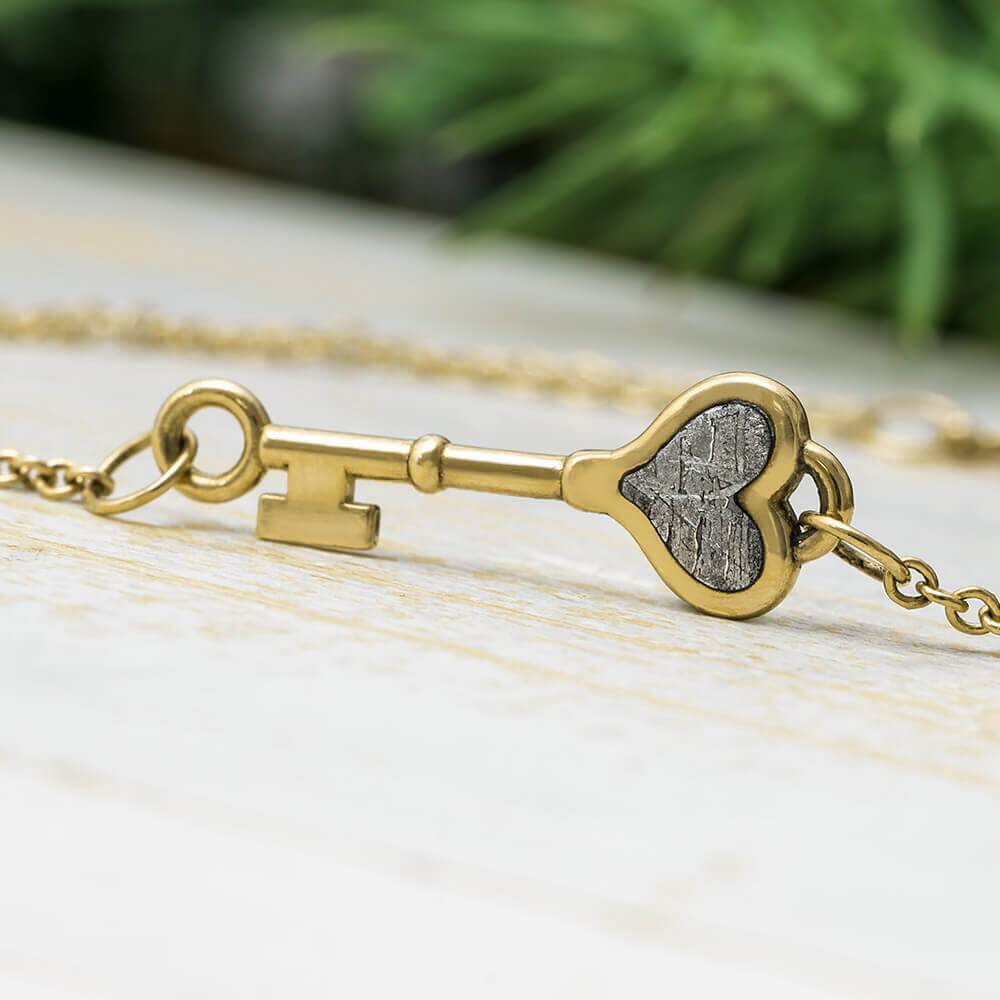 Gold tiny key bracelet with meteorite heart inlay
