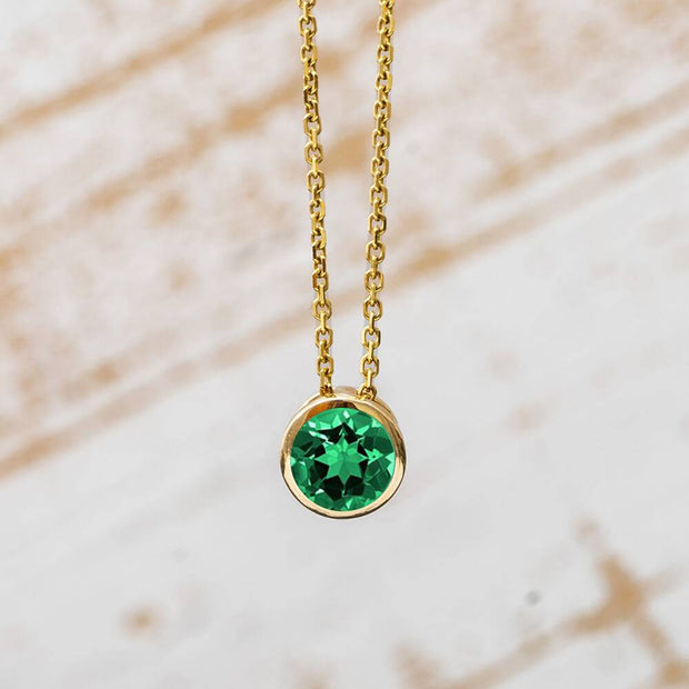 Gold bezel set necklace with green gemstone