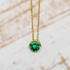 Gold bezel set necklace with green gemstone