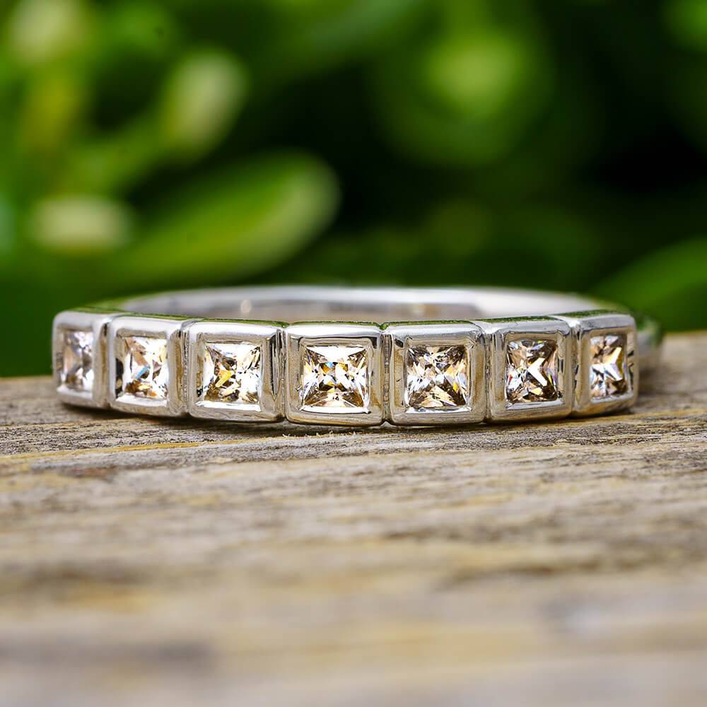 Square cut diamond anniversary band with bezel setting outdoors