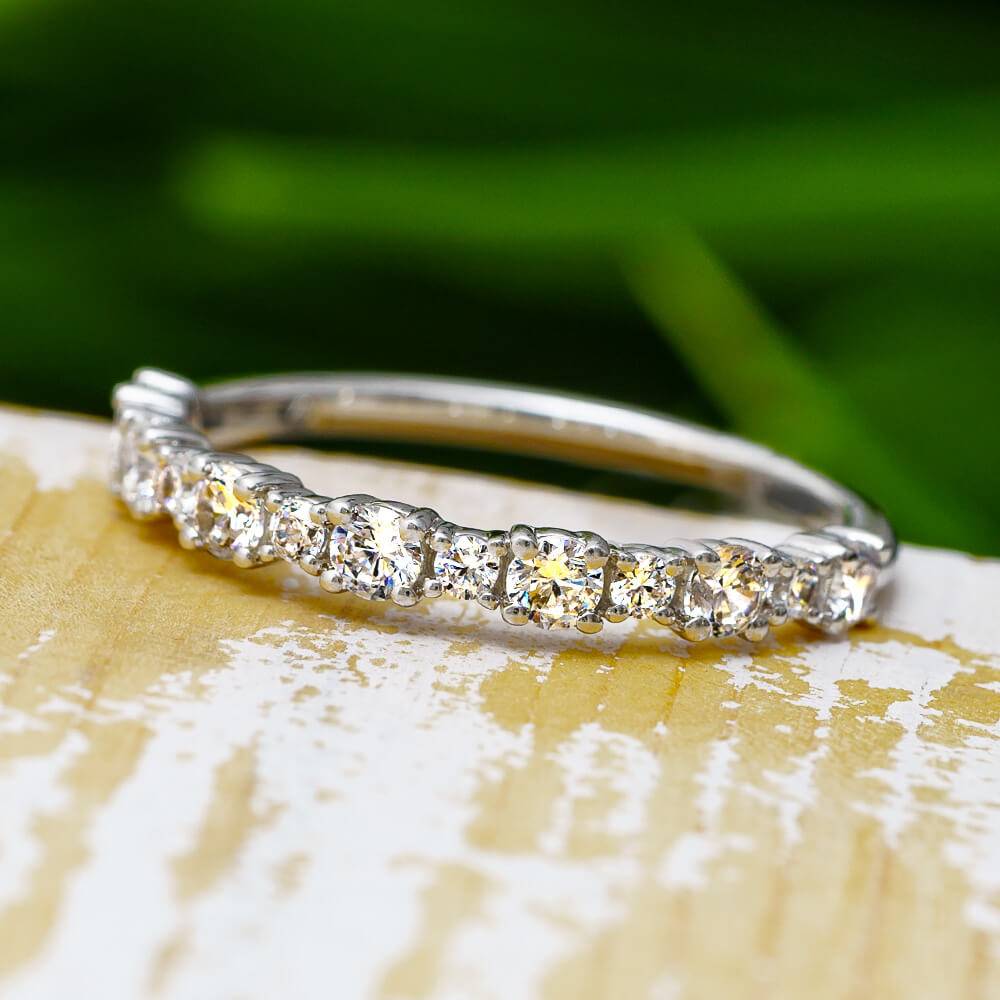 Round cut diamond half eternity band on wood surface