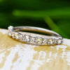 Round cut diamond half eternity band on wood surface