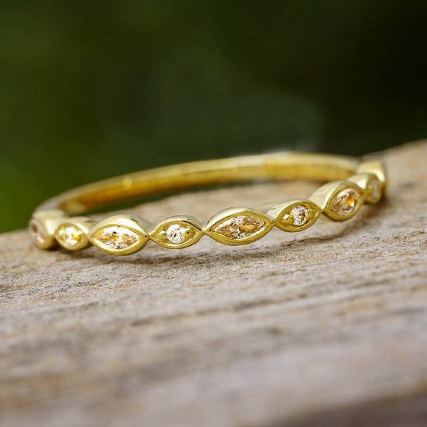 Yellow gold diamond stackable band on wood surface