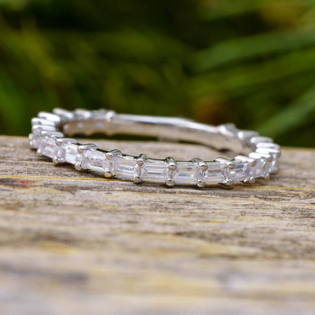 Straight baguette diamond wedding band on wood surface