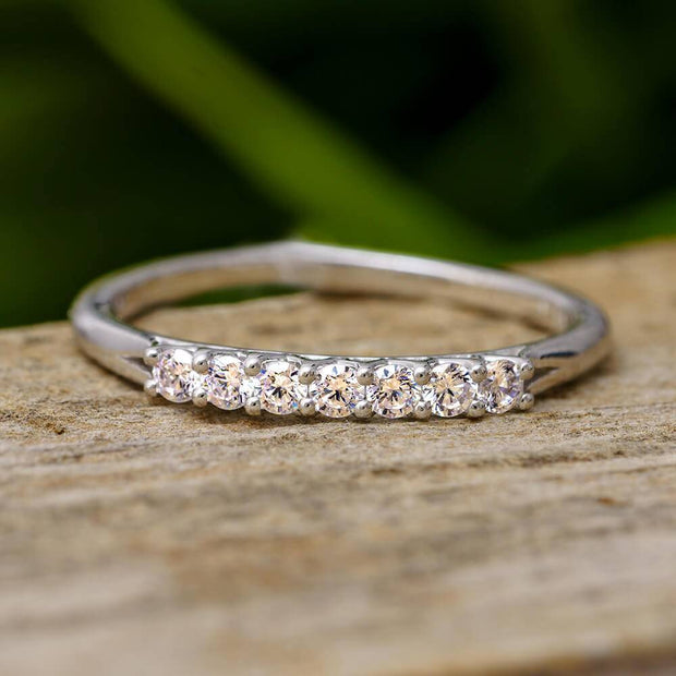 7-stone diamond ring with V-shaped prong on wood