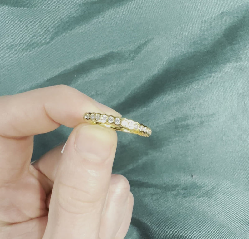 Hand holding yellow gold diamond anniversary band