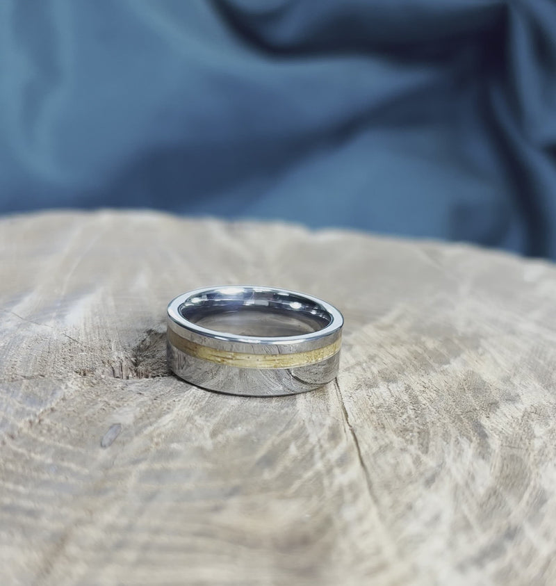 Tungsten ring with whiskey barrel oak inlay on wood surface