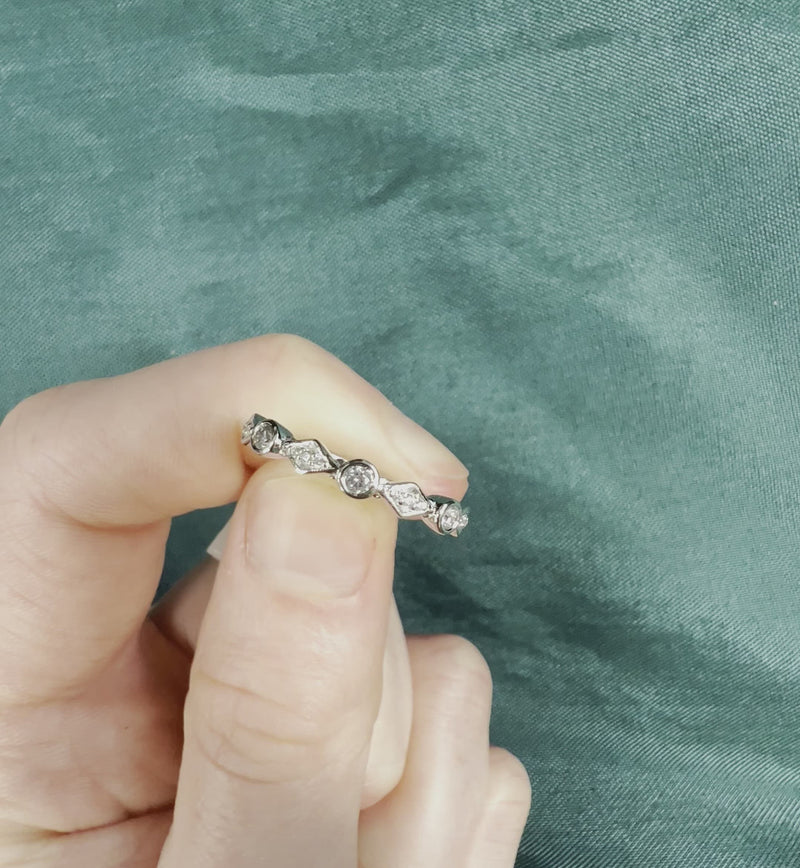 Hand holding diamond stackable band with circles and diamonds