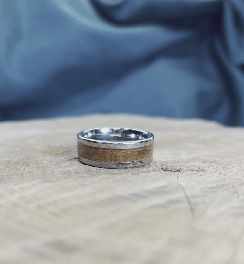 Tungsten oak wood wedding band on wooden surface